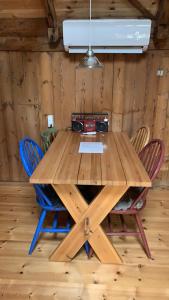 una mesa de madera con sillas en una habitación en Charming old style shanty en Hvalba