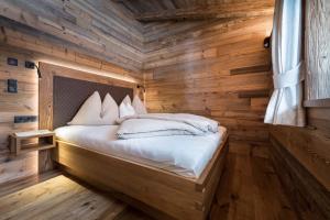 1 dormitorio con 1 cama en una pared de madera en Chalet-karwendel en Terfens