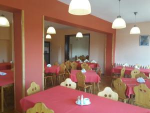 a dining room with red tables and chairs at Dom Wypoczynkowy Pod Taborem in Niedzica Zamek