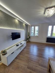 a living room with a flat screen tv on a wall at Nowoczesny apartament w zacisznym sercu Torunia. in Toruń