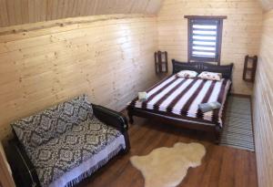 1 dormitorio con cama, ventana y alfombra en Садиба під Чертежиком 2, en Kolochava