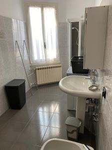 a white bathroom with a sink and a toilet at Affittacamere Derby in Ranica