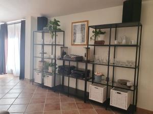 Zimmer mit Regalen mit Geschirr und Pflanzen in der Unterkunft Open Space Rose in Iglesias