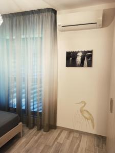 a bedroom with a bird painting on the wall at Sogni d'orto in Castiglione della Pescaia