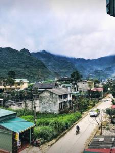 a town with a mountain in the background with a street at Meo Vac Cosy Hostel in Mèo Vạc