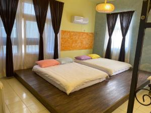 2 Betten in einem Zimmer mit Fenstern in der Unterkunft 珊瑚礁民宿 in Magong