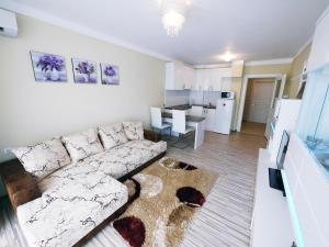 uma sala de estar com um sofá e uma cozinha em APART-HOTEL Stamopolu Lux с изглед към морето em Primorsko