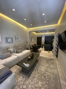ein Wohnzimmer mit einem Sofa und einem Tisch in der Unterkunft CASAGOLD Glyfada Luxury Apartment Near The Sea in Athen