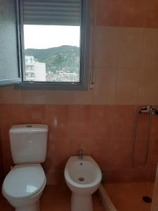 een badkamer met een toilet en een raam bij Grazioso Monolocale arredato a due passi dal lungomare vlore in Vlorë