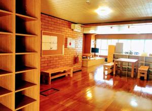 a room with a library with benches and a table at Guest House Yun Terrace in Ishigaki Island