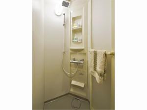 a small bathroom with a shower and towels at 西船橋駅前 HOTEL in Funabashi