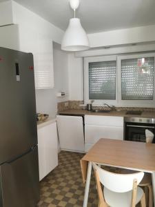 a kitchen with a wooden table and a refrigerator at Pyramides22 maison de ville de charme in Mulhouse
