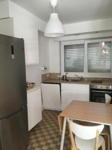 a kitchen with a wooden table and a refrigerator at Pyramides, maison de ville de charme 6pers, 2 Chambres, terrasse in Mulhouse +5 photos