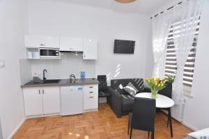 een keuken en een woonkamer met een tafel en een bank bij Studio Sanowa in Przemyśl
