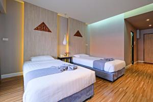 two beds in a room with wooden floors at Green Lake Resort - SHA Extra Plus Certified in Chiang Mai