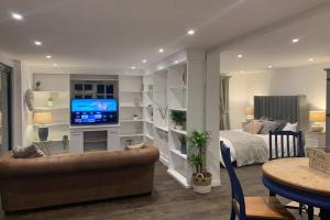 a living room with a bed and a television at Clock Cottage Self contained Rutland Rural Retreat in Manton