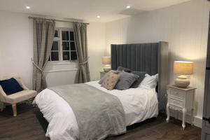 a bedroom with a large bed and a chair at Clock Cottage Self contained Rutland Rural Retreat in Manton