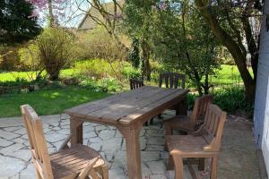 a wooden table and chairs sitting on a patio at Clock Cottage Self contained Rutland Rural Retreat in Manton