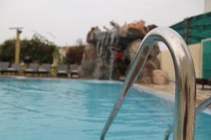 a swimming pool with a water fountain at Hotel Surya, Kaiser Palace in Varanasi