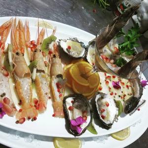 a plate of food with seafood on a table at Hotel De Luna in Ksamil