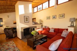 sala de estar con sofá rojo y chimenea en Shutters on Hilltop, Scarborough en Scarborough