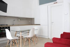 a kitchen with a glass table and white chairs at Dimora Vanni "civico 5" "civico 9" in Polignano a Mare