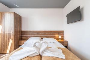 łóżko z dwoma ręcznikami w kształcie serca w obiekcie Pastelowy Mrzeżyno w mieście Mrzeżyno