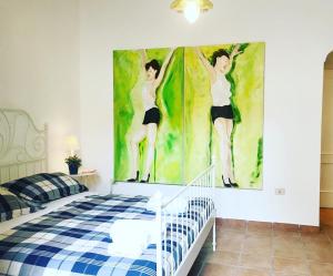 ein Schlafzimmer mit einem Gemälde von zwei tanzenden Frauen in der Unterkunft B&B La Corte in SantʼAntimo