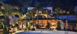 a large building with palm trees in front of it at Villa Timea Piscina e Tennis Vista Isole Egadi in Marsala