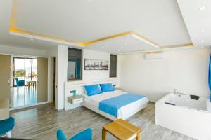 a bedroom with a bed and a sink and chairs at VillA Esin in Kaş
