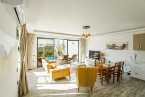 a living room with a couch and chairs and a table at VillA Esin in Kaş