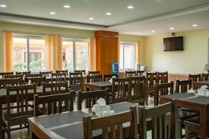 uma sala de jantar com mesas e cadeiras e uma TV em Hotel Elegant em Pokhara