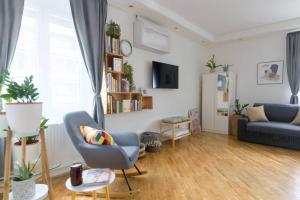 un soggiorno con divano e sedia di Hygge Apartman a Győr