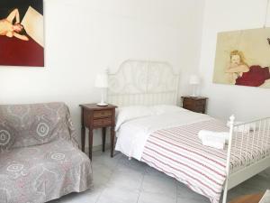 - une chambre avec un lit blanc et une chaise dans l'établissement B&B La Corte, à SantʼAntimo