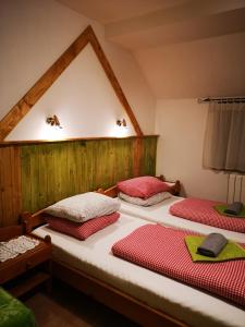um quarto com 2 camas com almofadas vermelhas e brancas em Penzión Pod orechom em Turčianske Teplice