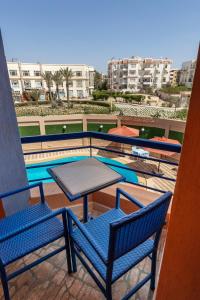 a table and chairs on a balcony with a pool at Royal Day Plaza Hotel in 6th Of October