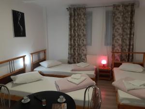 Una habitación con tres camas y una mesa dentro. en Carol 51 Hostel, en Bucarest