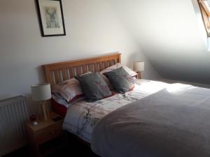 a bedroom with a bed with two pillows on it at 3 Knocknaha Cottage in Campbeltown