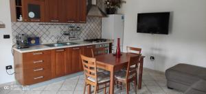 a kitchen with a table and chairs and a kitchen with a tv at Trilocale La Corte in Montaquila