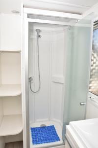 a shower with a glass door in a bathroom at Retiro da Praia da Aguda in Arcozelo