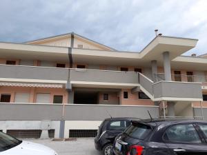 a building with cars parked in front of it at TERRAZZA SUL MARE in Marotta