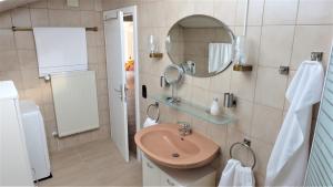 un baño con lavabo y espejo en Ferienwohnung Kaiserblick, en Stephanskirchen 44 fotos más