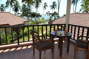 a patio area with a patio table and chairs at Lanka Beach Bungalows in Tangalle