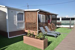 a deck with two chairs and a house at Retiro da Praia da Aguda in Arcozelo