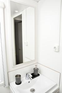 y baño con lavabo blanco y espejo. en Retiro da Praia da Aguda, en Arcozelo
