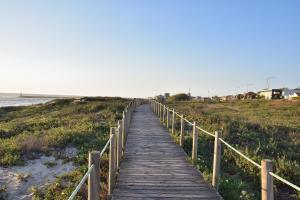 a wooden boardwalk leading down to the beach at Retiro da Praia da Aguda in Arcozelo