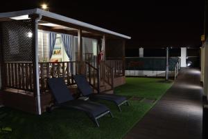 a gazebo with chairs on a lawn at night at Retiro da Praia da Aguda in Arcozelo