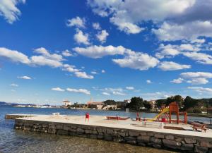 a dock with a playground on the water at Petra's garden in Kraj