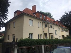 a large white house with a red roof at Ferienwohnung Tapetenwechsel -Balkon- in Dresden