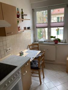 eine Küche mit einem Tisch und Stühlen sowie einem Fenster in der Unterkunft Ferienwohnung Tapetenwechsel -Balkon- in Dresden